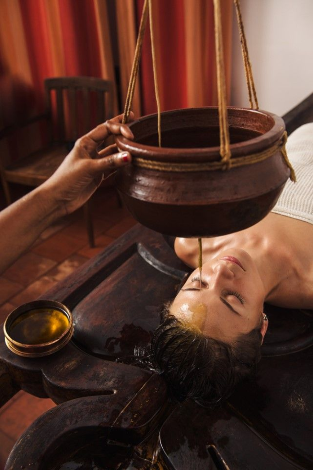 Woman receiving a traditional wellness oil treatment