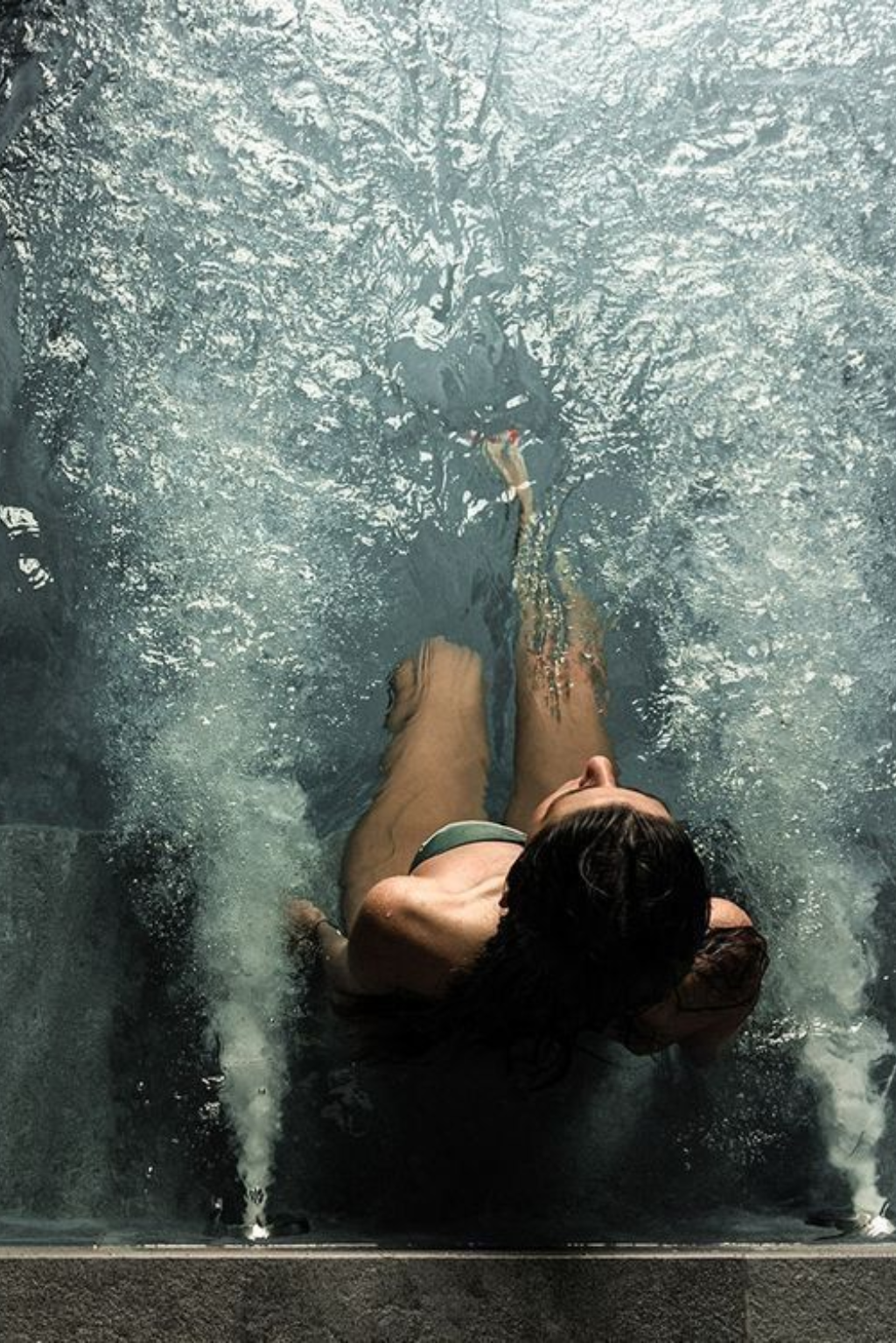 Woman relaxing in a hydrotherapy pool surrounded by trees